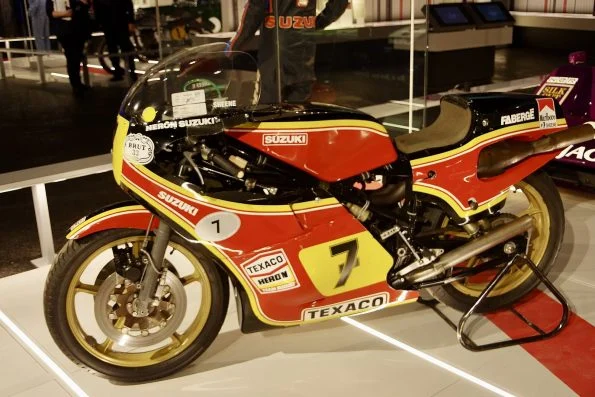 Barry Sheene's red and yellow Texaco Heron Suzuki RG500, carrying race number 7 on a yellow disc, on a museum display stand.