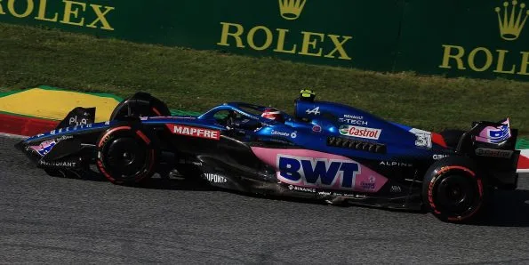 Esteban Ocon driving the Alpine A522 in blue and pink at the 2022 Austrian Grand Prix