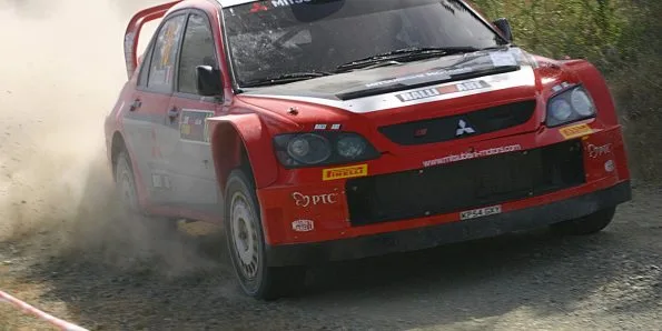 Mitsubishi rally car in red and white Ralliart livery on a gravel stage at the 2005 Cyprus Rally