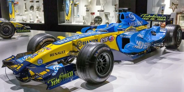 Renault R26 in blue and yellow, front three-quarter view on museum display