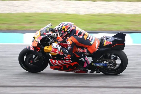 Enea Bastianini leaning his orange Red Bull KTM Tech3 machine through a corner at the 2025 Malaysian motorcycle Grand Prix.