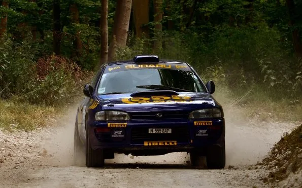Subaru World Rally Team Impreza WRC navigating a gravel stage during the final championship years featuring champions Richard Burns and Petter Solberg