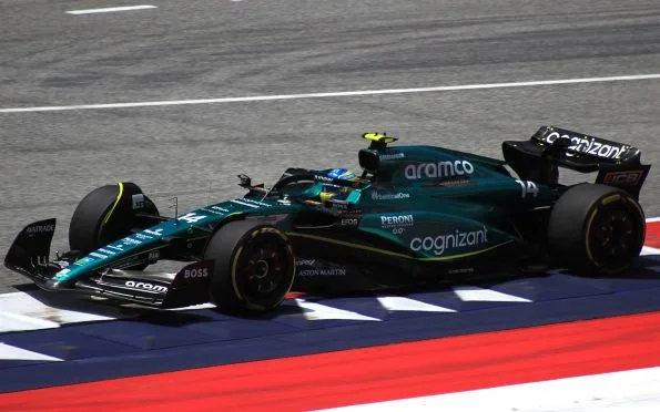 Aston Martin AMR23 Formula 1 race car in iconic British Racing Green driven by Fernando Alonso during a Grand Prix weekend.