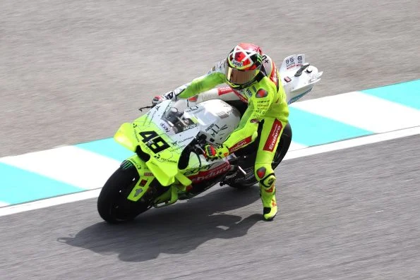 Fabio Di Giannantonio cornering his fluorescent yellow VR46 Racing Team Ducati, number 49, at the Malaysian Grand Prix.