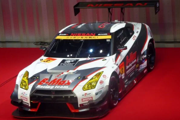 Jann Mardenborough's #3 B-MAX Racing Nissan GT-R Nismo GT3 in white, red, and black Super GT livery on a red display floor.