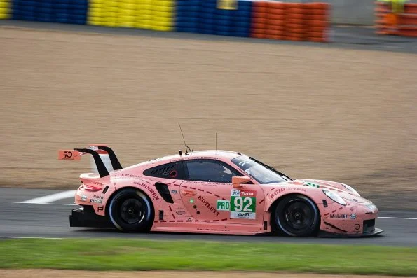 Kévin Estre's number 92 Porsche GT Team 911 RSR, featuring the famous pink 'Pink Pig' livery with dotted butcher-cut outlines, on track at Le Mans