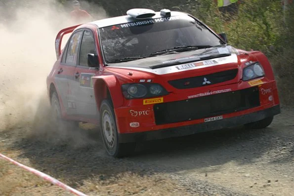 Mitsubishi Ralliart Lancer WRC competing on a tarmac stage during the brand's final works World Rally Championship season.