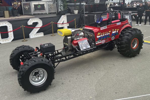 Tom Meents' restored red "Shake Me" mud racer featuring NMRO decals on display at a Monster Jam event.