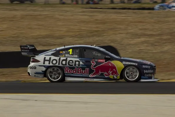 Whincup at speed in the dark blue number 1 Red Bull Holden ZB Commodore, his name printed along the roof rail