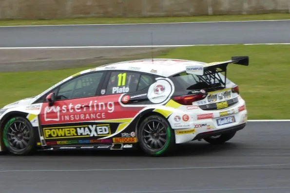 The white, red and black number 11 Power Maxed Racing Vauxhall Astra of Jason Plato, his name above the door, on track at Silverstone during the 2019 British Touring Car Championship.