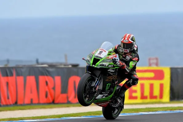 Rea on his green Kawasaki Racing Team Ninja ZX-10RR at Phillip Island in February 2020, front wheel light over a crest with the sea behind