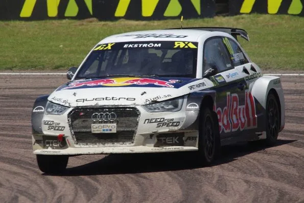 Ekström’s number 10 EKS Audi S1 quattro rallycross Supercar, white with Red Bull graphics and dirt down its flanks, turning into the Lydden Hill hairpin in 2015