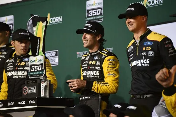 Ryan Blaney celebrating in the winners circle with the trophy and team members after winning the Iowa Corn 350 at Iowa Speedway on 16 June 2024.