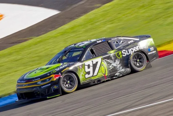 Shane van Gisbergen in the black and green number 97 Trackhouse Racing Chevrolet Camaro ZL1 at speed on the Watkins Glen road course in 2026.