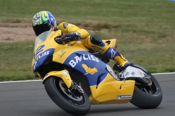 Bayliss knee-down on his yellow and blue Camel Honda MotoGP machine, his name on the tail, at the 2005 British Grand Prix at Donington Park